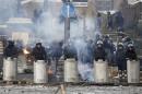 Riot police stand in formation facing anti-government protesters in Kiev
