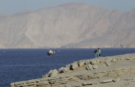 <p>               In this Jan. 18, 2012 photo, a tourist couple watches the mountains in south of the Strait of Hormuz as the trading dhows and ships are docked on the Persian Gulf waters near the town of Khasab, in Oman. Even as sanctions squeeze Iran ever tighter, there's one clandestine route that remains open for business: A short sea corridor connecting a rocky nub of Oman with the Iranian coast about 35 miles (60 kilometers) across the Gulf. (AP Photo/Kamran Jebreili)