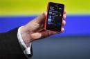 A Nokia official displays a new $99 phone in its mid-range Asha line at a launch in New Delhi