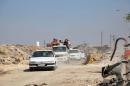 People drive in the Ramousah area of southern Aleppo
