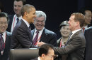 U.S. President Barack Obama, left, smiles with Russian President Dmitry Medvedev, right, as they attend the opening plenary session at the Nuclear Security Summit at the Coex Center, in Seoul, South Korea, Tuesday, March 27, 2012. Sitting in the center is South Korean President Lee Myung-bak. (AP Photo/Pablo Martinez Monsivais)