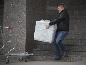 A man carries a dishwasher machine he purchased from &hellip;