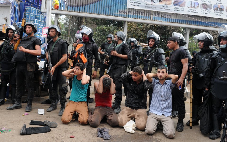 Egyptian security forces detain supporters of ousted Islamist President Mohammed Morsi as they clear a sit-in camp set up near Cairo University in Cairo's Giza district, Egypt, Wednesday, Aug. 14, 2013. Egyptian police in riot gear swept in with armored vehicles and bulldozers Wednesday to clear the sit-in camp and the other set up by supporters of the country's ousted Islamist president in Cairo, showering protesters with tear gas as the sound of gunfire rang out. (AP Photo/Mohammed Asad)