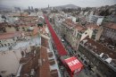 Red chairs are displayed along a main street in Sarajevo as the city marks the 20th anniversary of the start of the Bosnian war on Friday, April 6, 2012. City officials have lined up 11,541 red chairs arranged in 825 rows along the main street that now looks like a red river representing the 11,541 Sarajevans who were killed during the siege.(AP Photo/Amel Emric)