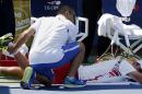 Ivan Dodig, of Croatia, is treated by a trainer during an injury timeout during the second round of the 2014 U.S. Open tennis tournament against Feliciano Lopez, of Spain, Wednesday, Aug. 27, 2014, in New York. Dodig forfeited the match to Lopez in the fifth set. (AP Photo/Kathy Willens)
