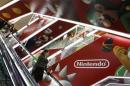 People ride an escalator past Nintendo Co advertisements at an electronics retail store in Tokyo