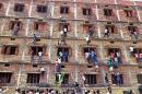 CAPTION CORRECTS THE YEAR - FILE - In this Wednesday, March 18, 2015 file photo, Indians climb the wall of a building to help students appearing in an examination in Hajipur, in the eastern Indian state of Bihar. Education authorities in eastern India say 600 high school students have been expelled after they were found to have cheated on pressure-packed 10th grade examinations. (AP Photo/Press Trust of India, File) INDIA OUT