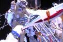 Russian astronaut Oleg Kotov holds an Olympic torch as he takes it on a spacewalk as Russian astronaut Sergei Ryazansky gives instructions outside the International Space Station