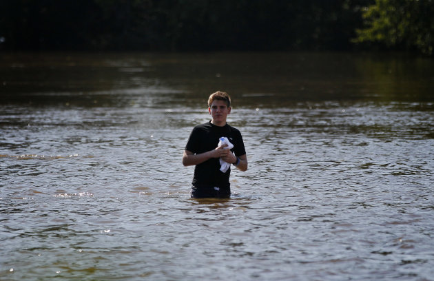 Nick Grassett walks through floodwater that rose above the banks of the St. Jones River in Dover, Del., Sunday, Aug. 28, 2011, after Hurricane Irene dumped several inches of rain along the Delaware co