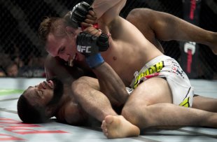 Rory MacDonald pins down Tyron Woodley during their welterweight title fight. (AP)