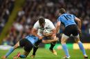 England's number 8 Nick Easter (C) is tackled by Uruguary's full-back Gaston Mieres (L) and Uruguary's fly half Felipe Berchesi (R) during the Pool A match of the 2015 Rugby World Cup in Manchester, northwest England, on October 10, 2015