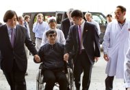 In this photo released by the US Embassy Beijing Press Office, blind lawyer Chen Guangcheng is wheeled into a hospital by U.S. Ambassador to China Gary Locke, right, and an unidentified official at left, in Beijing Wednesday May 2, 2012. (AP Photo/US Embassy Beijing Press Office, HO)