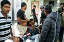 In this image taken on Wednesday, April 17, 2013, unidentified migrant workers receive first aid at the Medical Center of Varda, in Greece. At least 20 migrant strawberry pickers, most of them from Bangladesh, were shot and wounded in southern Greece on Wednesday, in a pay dispute after a foreman opened fire on them with a shotgun, police said. The incident occurred near the village of Manolada about 260 kilometers (160 miles) west of Athens. (AP Photo/EUROKINISSI) GREECE OUT
