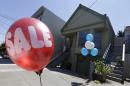 A sale balloon for a nearby store is shown next to a property in the Noe Valley neighborhood just sold for $1.8 million in cash, $600,000 more than its asking price, in San Francisco, Wednesday, July 30, 2014. In the souped-up world of San Francisco real estate, where the median selling price for homes and condominiums hit seven figures for the first time last month, the cool million that would fetch a mansion on a few acres elsewhere will now barely cover the cost of an 800-square-foot starter home. (AP Photo/Jeff Chiu)