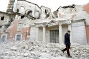 File photo shows an Italian military carabinieri walking on debris past destroyed buildings after an earthquake, in Aquila