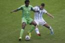 Nigeria's Efe Ambrose, left, and Argentina's Sergio Aguero battle for the ball during the group F World Cup soccer match between Nigeria and Argentina at the Estadio Beira-Rio in Porto Alegre, Brazil, Wednesday, June 25, 2014. (AP Photo/Michael Sohn)