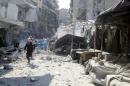 A civil defence member runs at a market hit by air strikes in Aleppo's rebel-held al-Fardous district