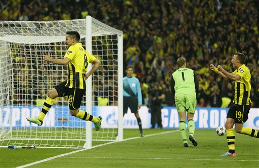 Dortmund's Ilkay Guendogan, left, reacts after scoring his side's first goal, during the Champions League Final soccer match between Borussia Dortmund and Bayern Munich at Wembley Stadium in London, S