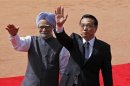 File photo of Chinese Premier Li and India's PM Singh waving towards the media during Li's ceremonial reception in New Delhi