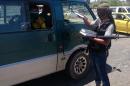 A fighter with the al-Qaida-inspired Islamic State of Iraq and the Levant (ISIL) distributes a copy of the Quran, Islam's holy book, to a driver in central northern city of Mosul, 225 miles (360 kilometers) northwest of Baghdad, Iraq, Sunday, June 22, 2014. Sunni militants on Sunday captured two border crossings, one along the frontier with Jordan and the other with Syria, security and military officials said, as they pressed on with their offensive in one of Iraq's most restive regions. (AP Photo)