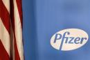 The Pfizer logo is seen next to a U.S. flag in a conference room at their world headquarters in New York