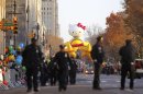 Policemen walk along Central Park West as the Hello Kitty balloon waits for the start of the 86th Macy's Thanksgiving Day Parade in New York