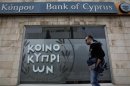 Man walks past a branch of Bank of Cyprus in Nicosia
