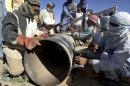 Pakistani employees of natural gas repair a damaged pipeline