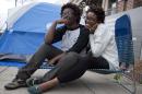 Shanté Wolfe, left and Tori Sisson, right, sit near the Montgomery County Courthouse Sunday, Feb. 8, 2015 in Montgomery, Ala. Wolfe and Sisson camped out all night on Sunday to be the first couple to marry in Montgomery on Monday morning. (AP Photo/Brynn Anderson)