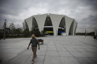 A worker walks near the outdoor diving pool Wednesday, July 13, 2011 at Shanghai Oriental Sports Center in Shanghai, China, ahead of the 14th FINA World Swimming Championships, which start from July 16. (AP Photo/Eugene Hoshiko)