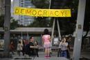 A girl poses next to a sign at an area blocked by pro-democracy protesters outside of the government headquarters building in Hong Kong