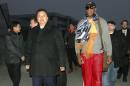 Dennis Rodman, derecha, ex astro de la NBA, camina junto al viceministro de Deportes norcoreano Son Kwang Ho a su arribo al aeropuerto internacional de Pyongyang, Corea del Norte, el jueves 19 de diciembre de 2013. (AP Foto/Kim Kwang Hyon)