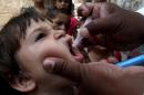A Pakistani health worker gives a polio vaccine to a child in Lahore, Pakistan, Monday, May 19, 2014. Pakistan will require all travelers leaving the country to obtain a polio vaccination from June 1, 2014, the health ministry said. (AP Photo/K.M. Chaudary)