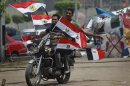 Two supporters of presidential candidate, Mohammed Morsi ride a motorcycle flying Egyptian flags during celebrations claiming victory over rival candidate, Ahmed Shafiq, in Tahrir Square, Cairo, Egypt Monday, June 18, 2012. The Muslim Brotherhood declared early Monday that its candidate, Mohammed Morsi, won Egypt's presidential election, which would be the first victory of an Islamist as head of state in the stunning wave of protests demanding democracy that swept the Middle East the past year. (AP Photo/Nasser Nasser)