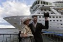 Mary Beth Crocker, left, and her husband Tom Dearing from Newport Ky. pose for pictures in period costume as they disembark the MS Balmoral Titanic memorial cruise ship at its first stop in Cobh, Ireland, Monday, April 9, 2012. Nearly 100 years after the Titanic went down, the cruise with the same number of passengers aboard is setting sail to retrace the ship's voyage, including a visit to the location where it sank.With 1,309 passengers aboard, the MS Balmoral will follow the same route as the Titanic and organizers are trying to recreate the onboard experience minus the disaster from the food to a band playing music from that era. (AP Photo/Lefteris Pitarakis)