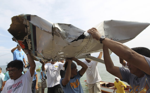 In this photo released by the Malacanang Photo Bureau, men carry parts of a crashed plane carrying Philippine Interior Secretary Jesse Robredo in Masbate city, Masbate province, central Philippines, Sunday, Aug. 19, 2012. About 300 rescuers were searching Sunday for Robredo and his two pilots after their small plane crashed into the sea while attempting an emergency landing on Saturday. (AP Photo/Malacanang Photo Bureau, Jay Morales) NO SALES
