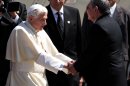 In this photo released by Cubadebate, Pope Benedict XVI, left, shakes hands with Cuba's President Raul Castro upon his arrival to the airport in Santiago de Cuba, Cuba, Monday March 26, 2012. (AP Photo/Ismael Francisco, Cubadebate)