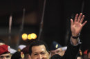 Venezuela's President Hugo Chavez waves after receiving military honors upon his arrival at the Simon Bolivar airport in Maiquetia , Venezuela, Friday March 16, 2012. Chavez returned home Friday nearly three weeks after undergoing cancer surgery in Cuba. (AP Photo/Fernando Llano)