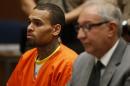 R&B singer Chris Brown, left, appears in Los Angeles Superior Court with his attorney Mark Geragos, on Monday, March 17, 2014. Brown will spend another month in jail after a judge said Monday he was told the singer made troubling comments in rehab about being good at using guns and knives. The singer was arrested on Friday, March 14, 2014, after he was dismissed from a Malibu facility where he was receiving treatment for anger management, substance abuse and issues related to bipolar disorder. (AP Photo/Lucy Nicholson, Pool)