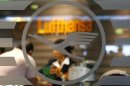 An employee of German air carrier Lufthansa is seen through a window at a rebooking counter at the Fraport airport in Frankfurt