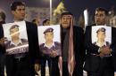 Relatives of Jordanian air force pilot Maaz al-Kassasbeh, who was burned alive by IS extremists, carry posters with his portrait and a slogan reading in Arabic "we are all Maaz" in Amman on January 27, 2015