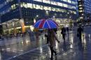Workers walk in the rain at the Canary Wharf business district in London