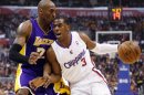 Los Angeles Clippers' Chris Paul handles the ball as Los Angeles Lakers' Kobe Bryant defends during the first quarter of their NBA basketball game in Los Angeles