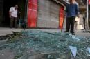 Residents look at the damage caused by a bomb blast at the Italian Consulate in Cairo
