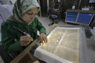 In this June 20, 2011 photo, Alaa Jassim, a member of the library restoration staff, works on a damaged document at the Iraq National Library and Archives in Baghdad. A trove of Jewish books and other materials, rescued from a sewage-filled Baghdad basement during the 2003 invasion and now stored at the National Archives and Records Administration in College Park, Md., near Washington, is now caught up in a tug-of-war between the U.S. and Iraq. (AP Photo/Khalid Mohammed)