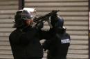 Police forces prepare in St. Denis, a northern suburb of Paris, Wednesday, Nov. 18, 2015. Authorities in the Paris suburb of St. Denis are telling residents to stay inside during a large police operation near France's national stadium that two officials say is linked to last week's deadly attacks. (AP Photo/Francois Mori)