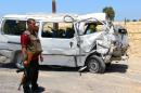 A member of the Egyptian security forces stands guard next to a damaged bus following a roadside bomb blast which wounded 20 Egyptian policemen on the outskirts of the northern Sinai's provincial capital of El-Arish on July 9, 2015