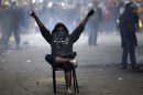 A protester opposing Egyptian President Mohamed Mursi gestures at riot police during clashes along Mohamed Mahmoud street which leads to the Interior Ministry, near Tahrir Square in Cairo