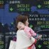 A woman carrying her baby walks by an electronic stock board of a securities firm in Tokyo, Monday, April 16, 2012. Asian stock markets sank Monday as Europe's debt crisis threatened to intensify again while growth in China slowed. Japan's Nikkei slid 167.35 points, or 1.74 percent, to close at 9,470.64 for the day, bruised by a higher yen. (AP Photo/Koji Sasahara)
