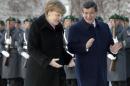 German Chancellor Angela Merkel, left, and Prime Minister of Turkey, Ahmet Davutoglu, right, gesture during a military welcome ceremony for a meeting at the Chancellery in Berlin, Germany, Friday, Jan. 22, 2016. (AP Photo/Michael Sohn)